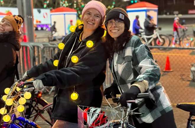 Friends Smile While Riding Bikes at Winter Wonderland's Bike the Lights Event in Portland, OR