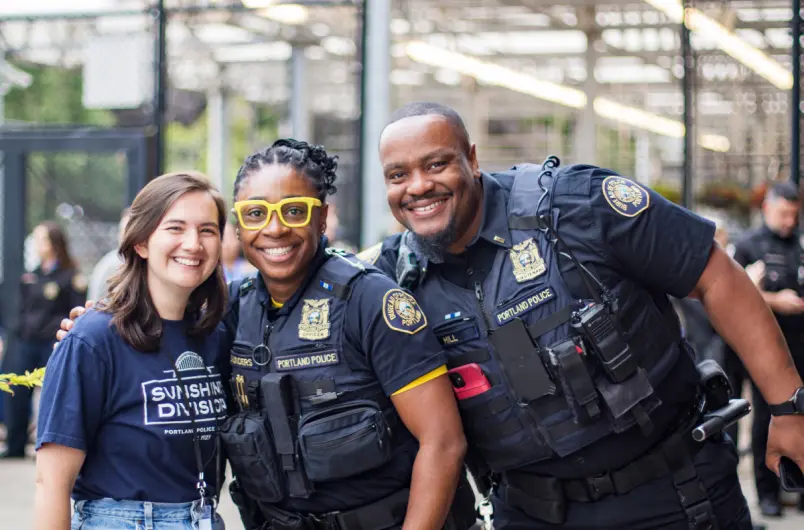 Portland Police Officers Pose for a Picture with a Sunshine Division Team Member